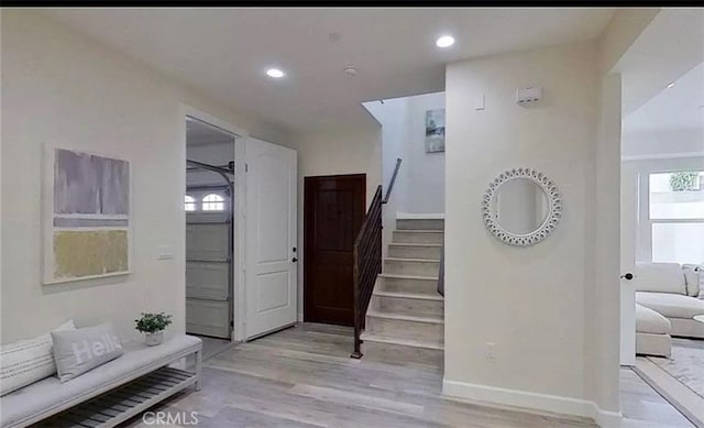 staircase with baseboards, wood finished floors, and recessed lighting