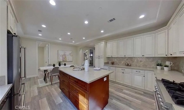 kitchen featuring stainless steel appliances, light wood-style flooring, light countertops, and white cabinetry