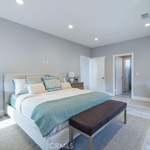 bedroom featuring baseboards, recessed lighting, visible vents, and light wood-style floors