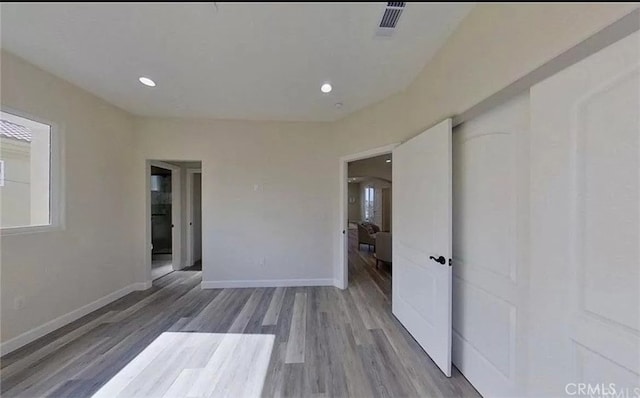 unfurnished room featuring recessed lighting, visible vents, baseboards, and wood finished floors