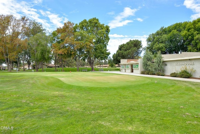 view of community with golf course view and a yard