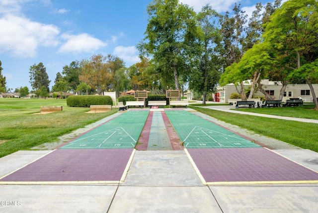 view of community featuring shuffleboard and a yard