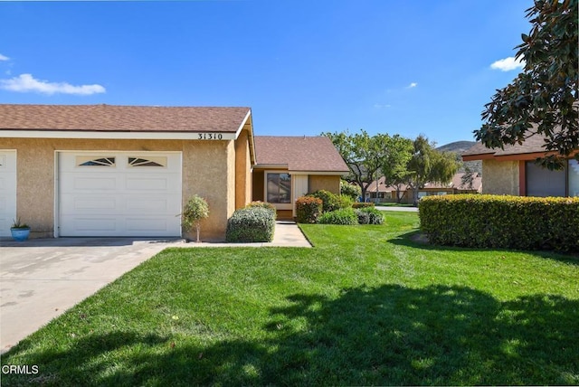 view of front facade with a garage, driveway, a front lawn, and stucco siding