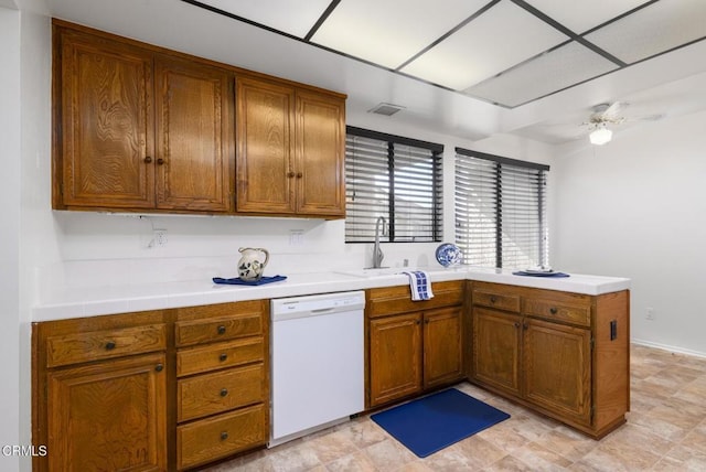 kitchen featuring a peninsula, white dishwasher, visible vents, and brown cabinets