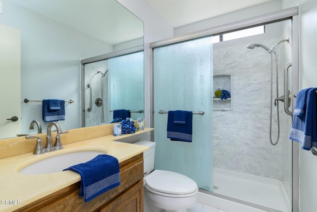 bathroom with a stall shower, vanity, and toilet