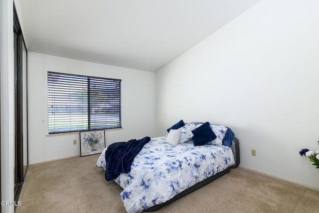 carpeted bedroom with lofted ceiling