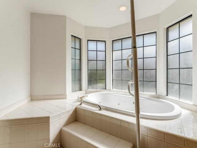 bathroom with a jetted tub and a healthy amount of sunlight