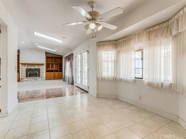 unfurnished living room with lofted ceiling, french doors, and light tile patterned floors