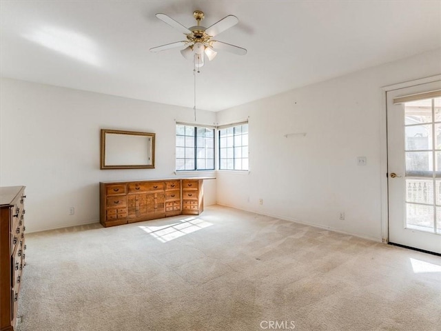 spare room featuring ceiling fan, plenty of natural light, and light colored carpet