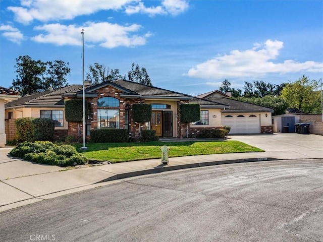 ranch-style house featuring an attached garage, driveway, a tiled roof, stucco siding, and a front yard