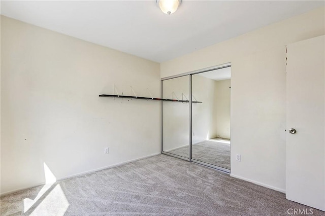 unfurnished bedroom with a closet and light carpet