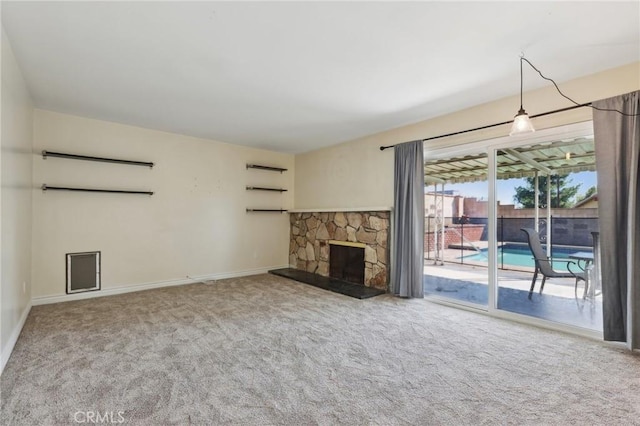 unfurnished living room featuring carpet, a fireplace, and baseboards