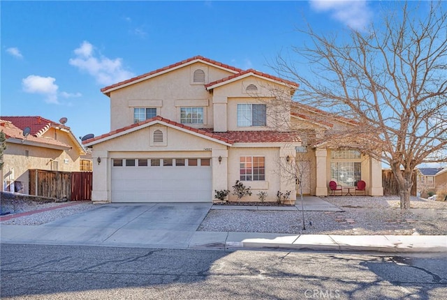 mediterranean / spanish-style home with stucco siding, concrete driveway, an attached garage, fence, and a tiled roof