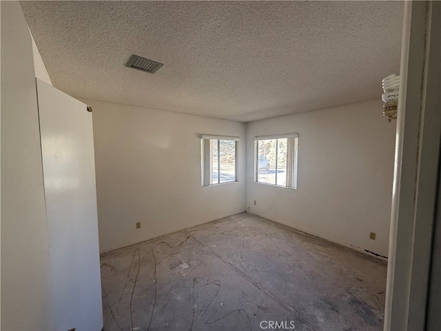 spare room featuring visible vents and a textured ceiling