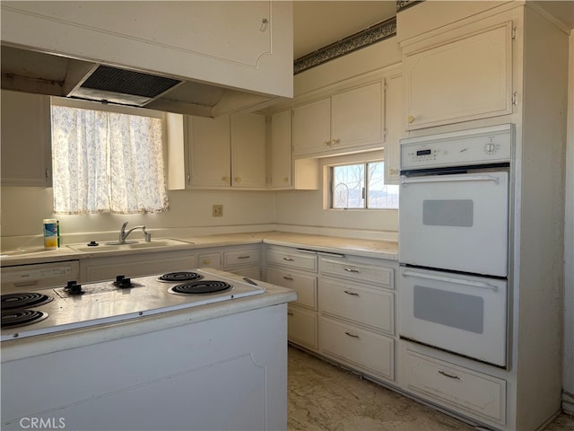 kitchen with white appliances, light countertops, a sink, and under cabinet range hood