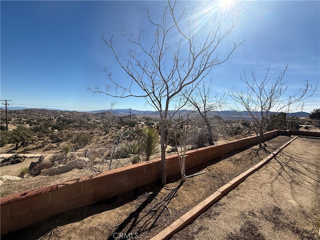 view of yard featuring fence and a mountain view