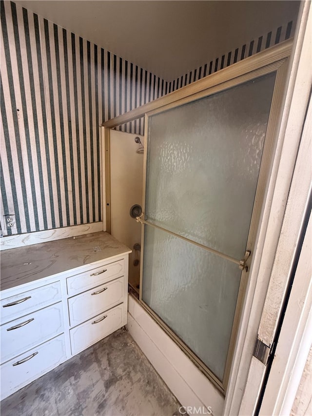 bathroom with bath / shower combo with glass door, unfinished concrete flooring, and wallpapered walls