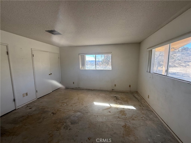 unfurnished bedroom featuring a textured ceiling and visible vents