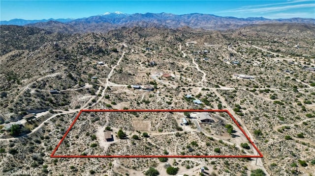 birds eye view of property with a mountain view and view of desert