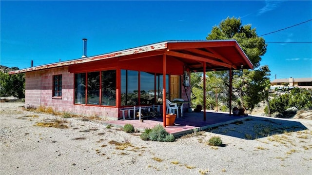 exterior space with a sunroom and concrete block siding