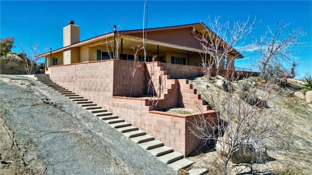 view of home's exterior with stairway and a chimney