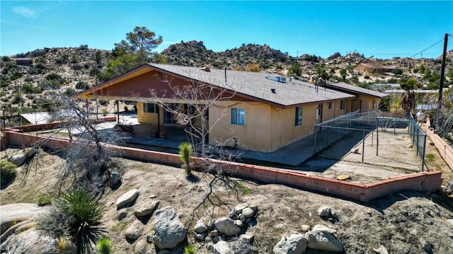 back of property featuring fence and stucco siding