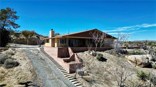 view of front of home featuring stairs and a chimney