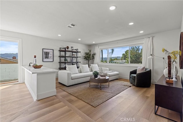 living area featuring recessed lighting, baseboards, visible vents, and light wood finished floors