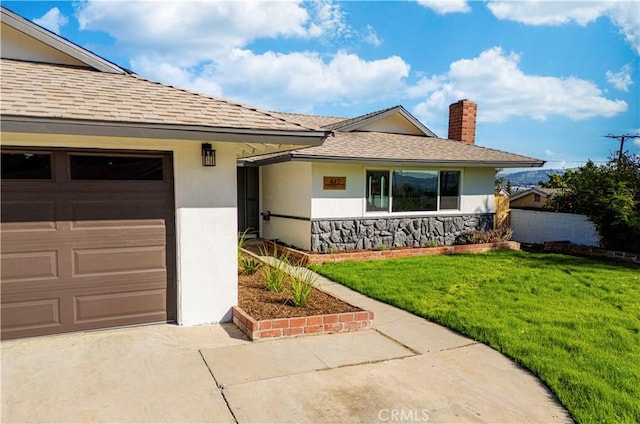 view of front of house with a garage, a front yard, a chimney, and stucco siding