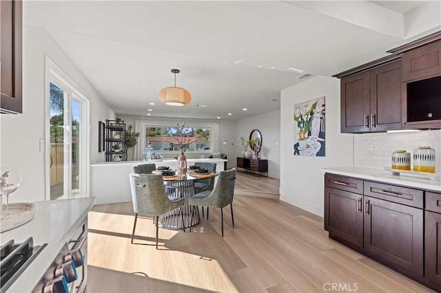 dining room featuring light wood-type flooring, baseboards, and recessed lighting