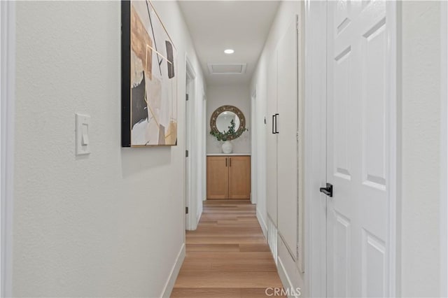 hall featuring recessed lighting, visible vents, light wood-style flooring, attic access, and baseboards