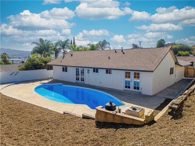 view of pool with a fenced in pool, a patio area, french doors, and a fenced backyard