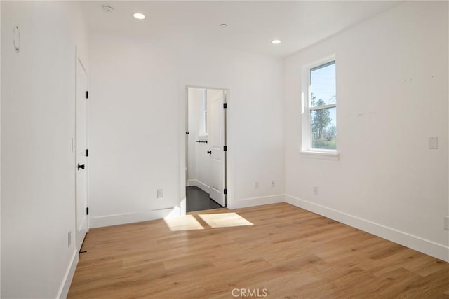 empty room with light wood finished floors, baseboards, and recessed lighting