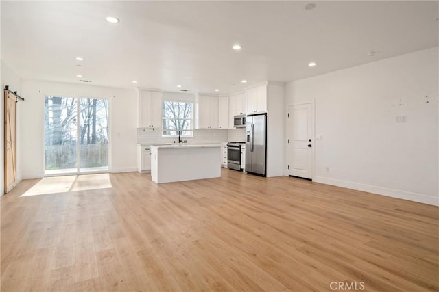 kitchen with open floor plan, stainless steel appliances, and light countertops