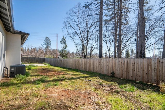 view of yard with a fenced backyard and central AC