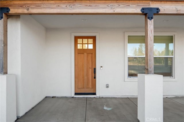 view of exterior entry featuring stucco siding