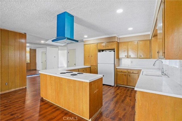 kitchen with island range hood, a peninsula, white appliances, a sink, and light countertops