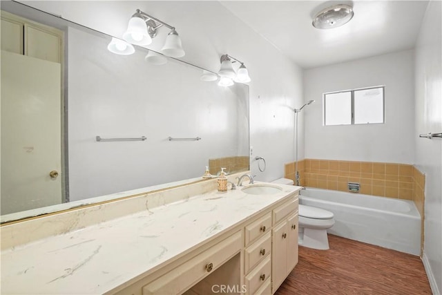 full bath featuring a tub, vanity, toilet, and wood finished floors