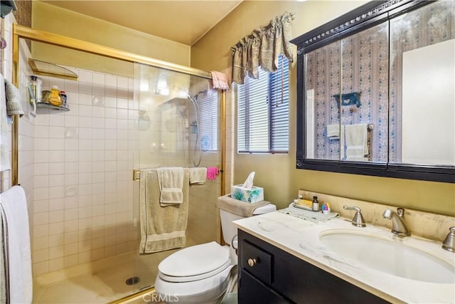 full bathroom featuring a stall shower, vanity, and toilet