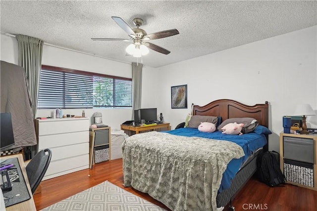 bedroom featuring a textured ceiling, ceiling fan, and wood finished floors