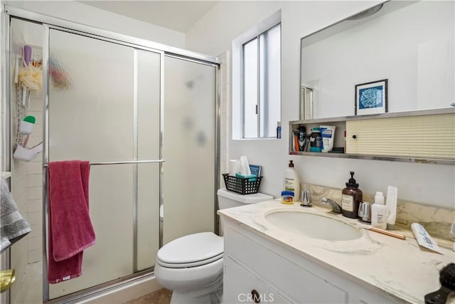 bathroom with a stall shower, vanity, and toilet