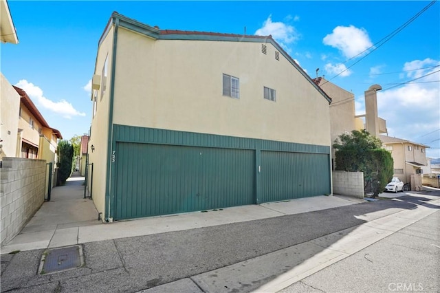 view of home's exterior with fence and stucco siding