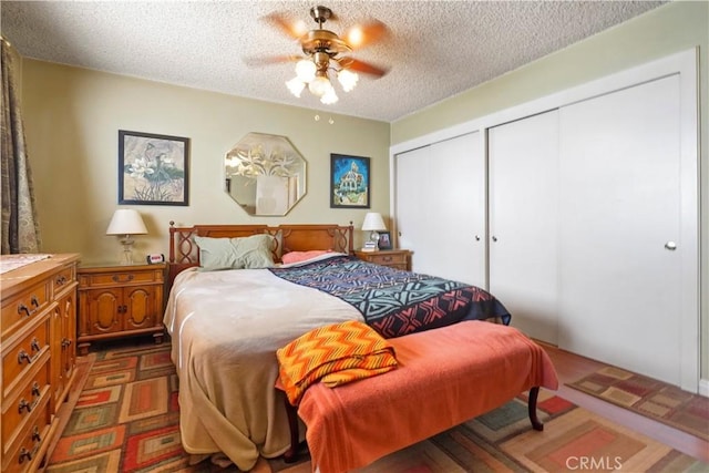 bedroom featuring a textured ceiling, ceiling fan, and two closets