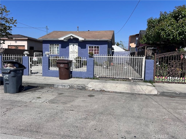 view of front of house with a fenced front yard, a gate, and stucco siding