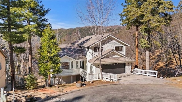 view of front facade with an attached garage, covered porch, and concrete driveway