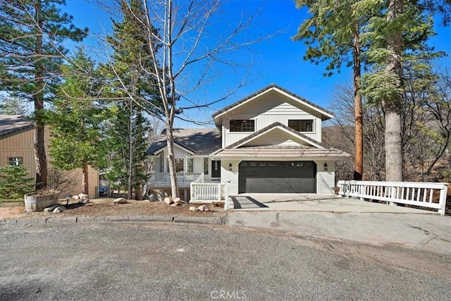 view of front of house featuring driveway, brick siding, and a porch