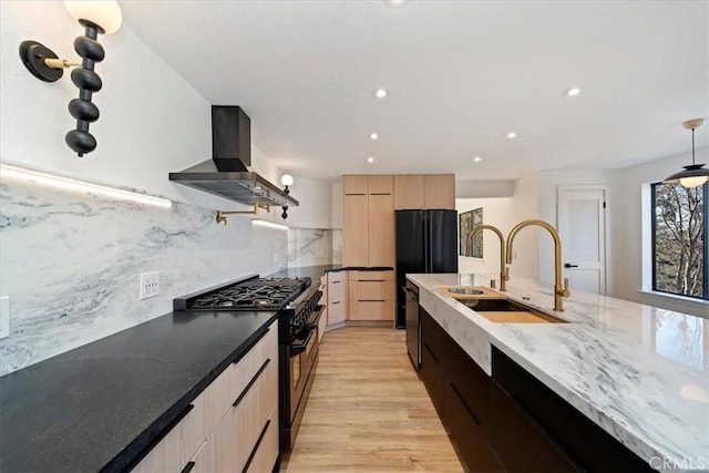 kitchen featuring modern cabinets, ventilation hood, light brown cabinetry, black appliances, and a sink