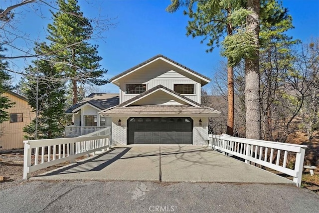 traditional home with a garage, driveway, and brick siding