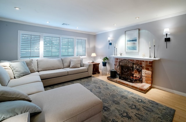 living room with a brick fireplace, visible vents, crown molding, and wood finished floors