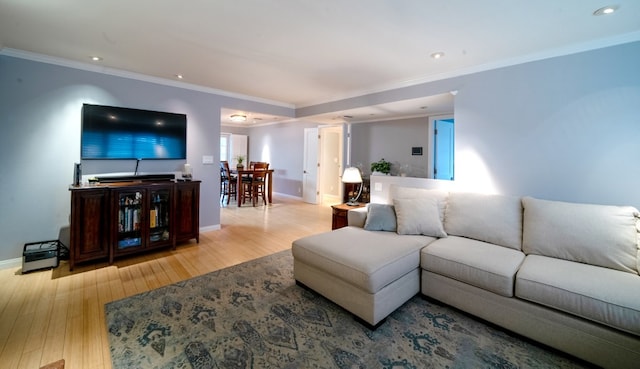 living area featuring ornamental molding, wood finished floors, and baseboards